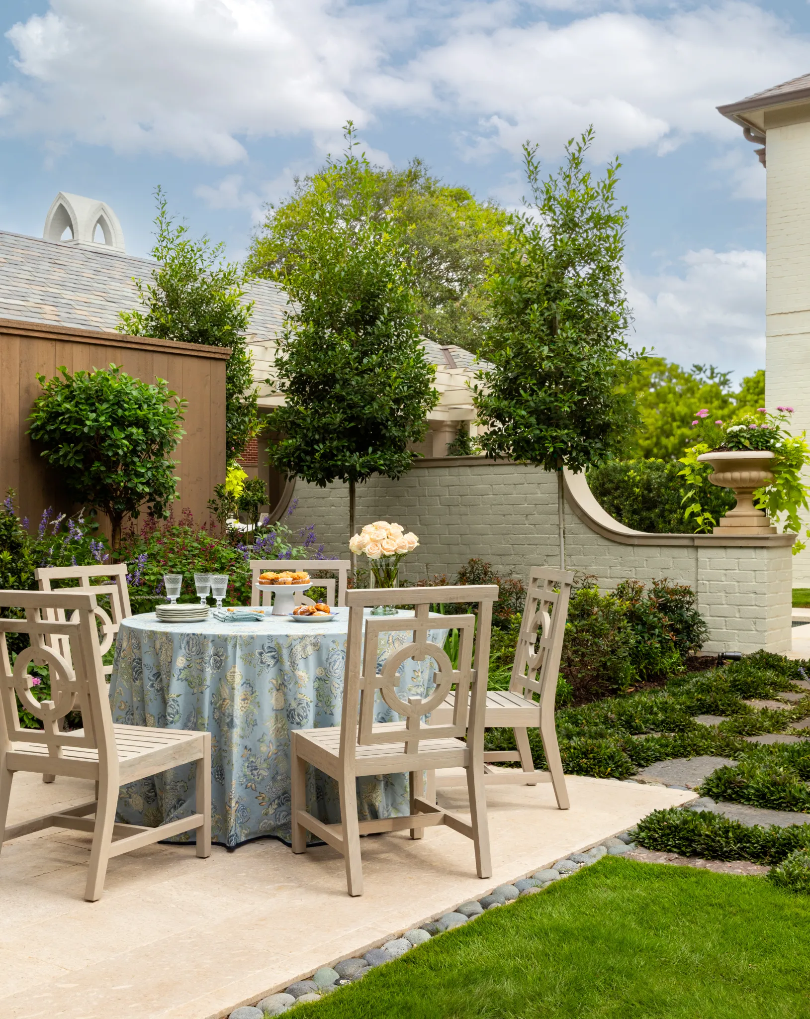 Garden dining table with a floral skirt set on a limestone terrace