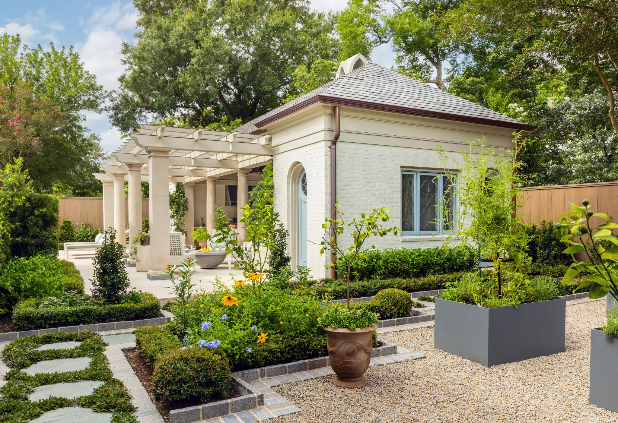 Pool house exterior with gravel garden, planter boxes, and flowering borders