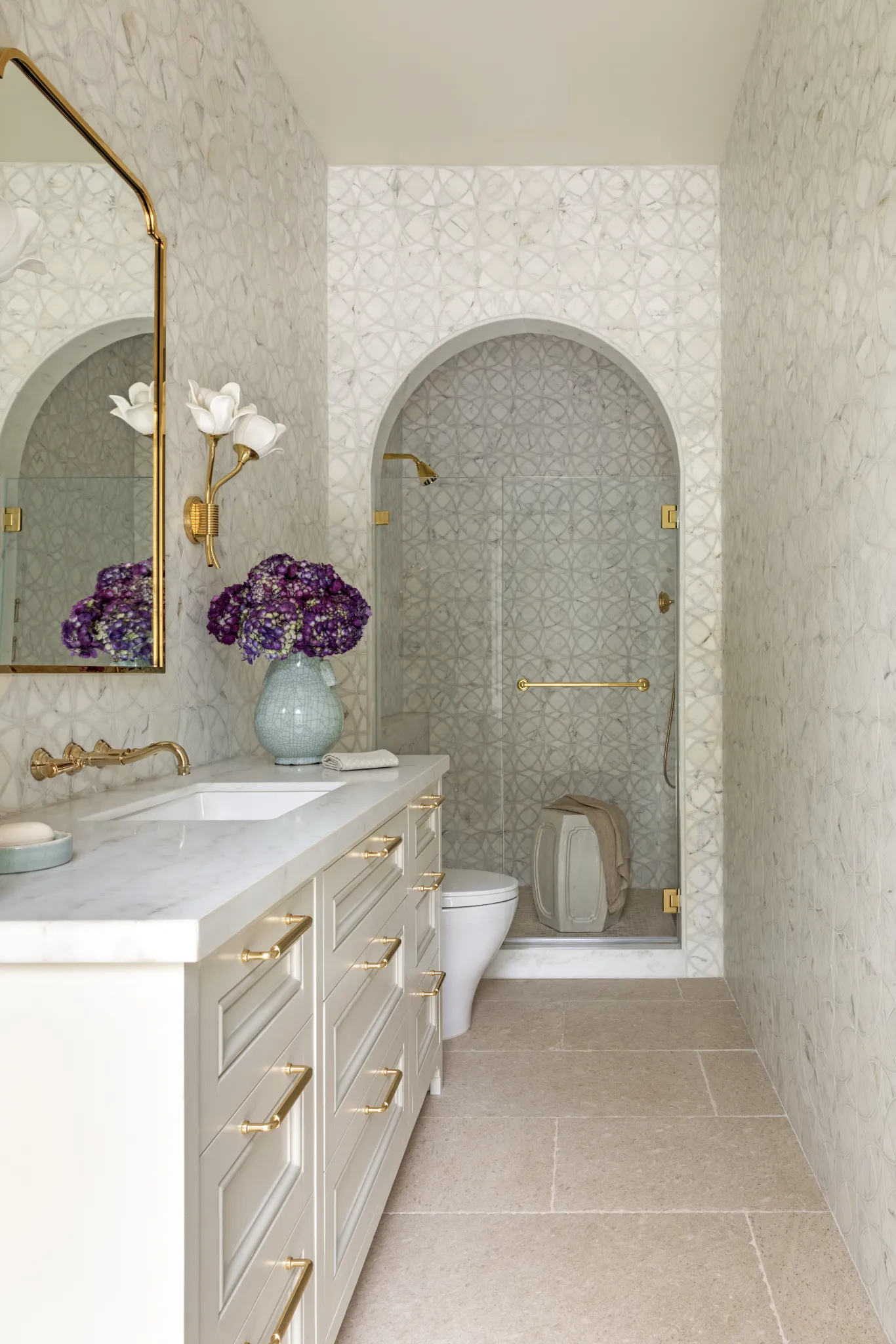 Pool bath with a marble-topped vanity, circle-pattern tile, and arched glass shower
